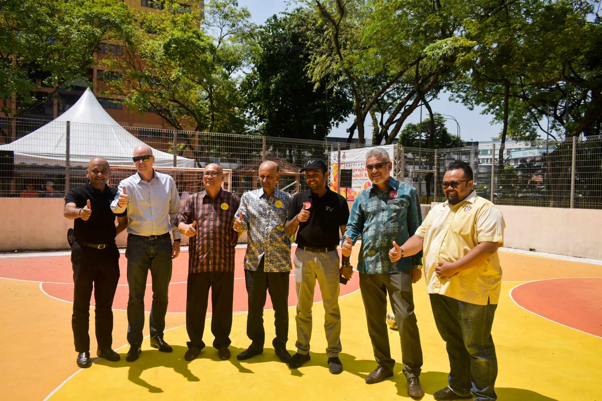 Community representatives gathering on a colourful sports court