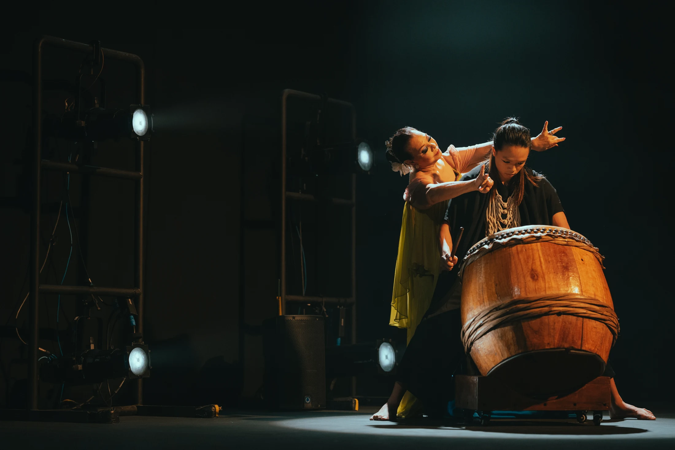 A Kelopak dancer performs alongside a drummer playing a large wooden drum